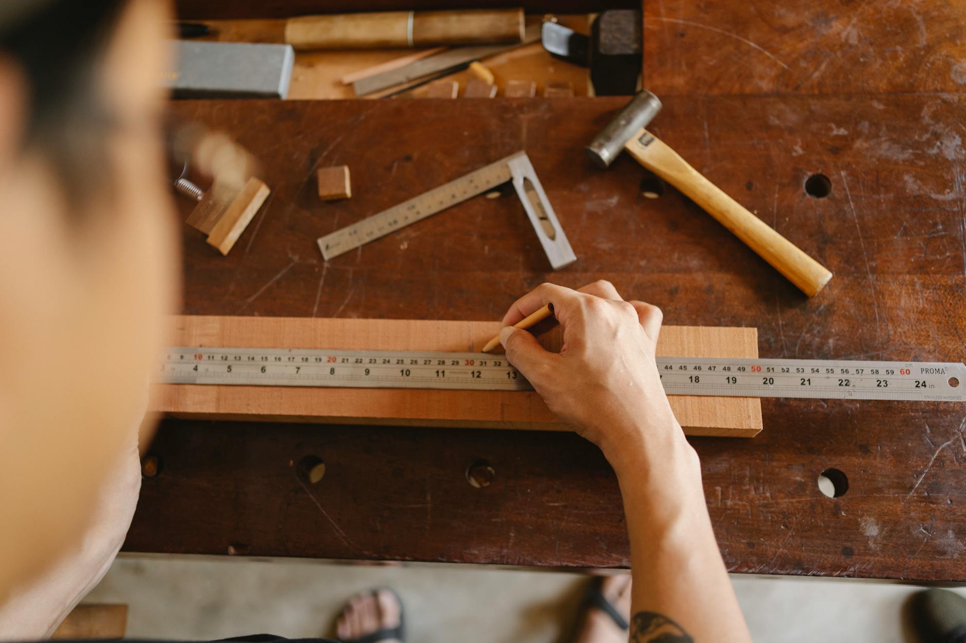 man working with ruler and wooden plank